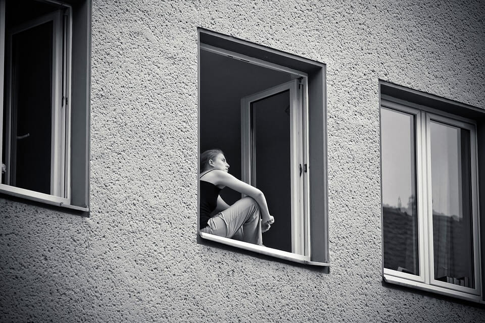 black and white woman in a window