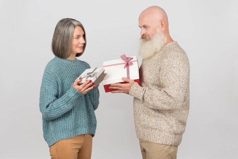 Old couple exchanging Christmas gifts