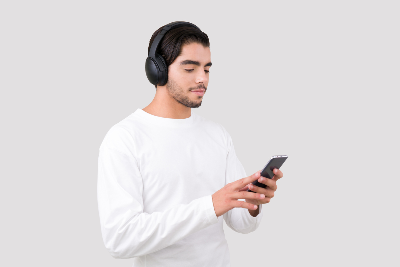Photo of a young handsome man in headphones listening to the music