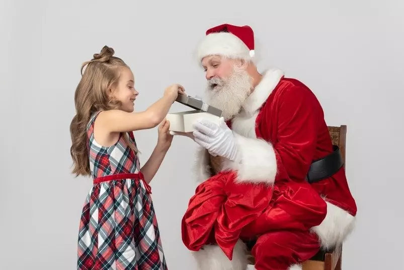 Santa Claus gives a present to a girl